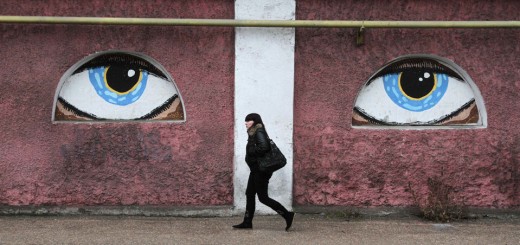 A woman walks past a building decorated with eyes in Crimean city of Sevastopol