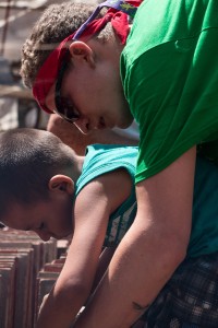 Andrew Kazel working with a local to file down tiles. Photo courtesy of Conrad Koehler